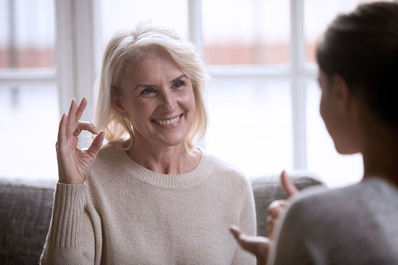 Frau übt mit Logopädin